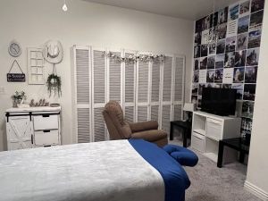Massage table with blue face cradle, recliner and photo wall